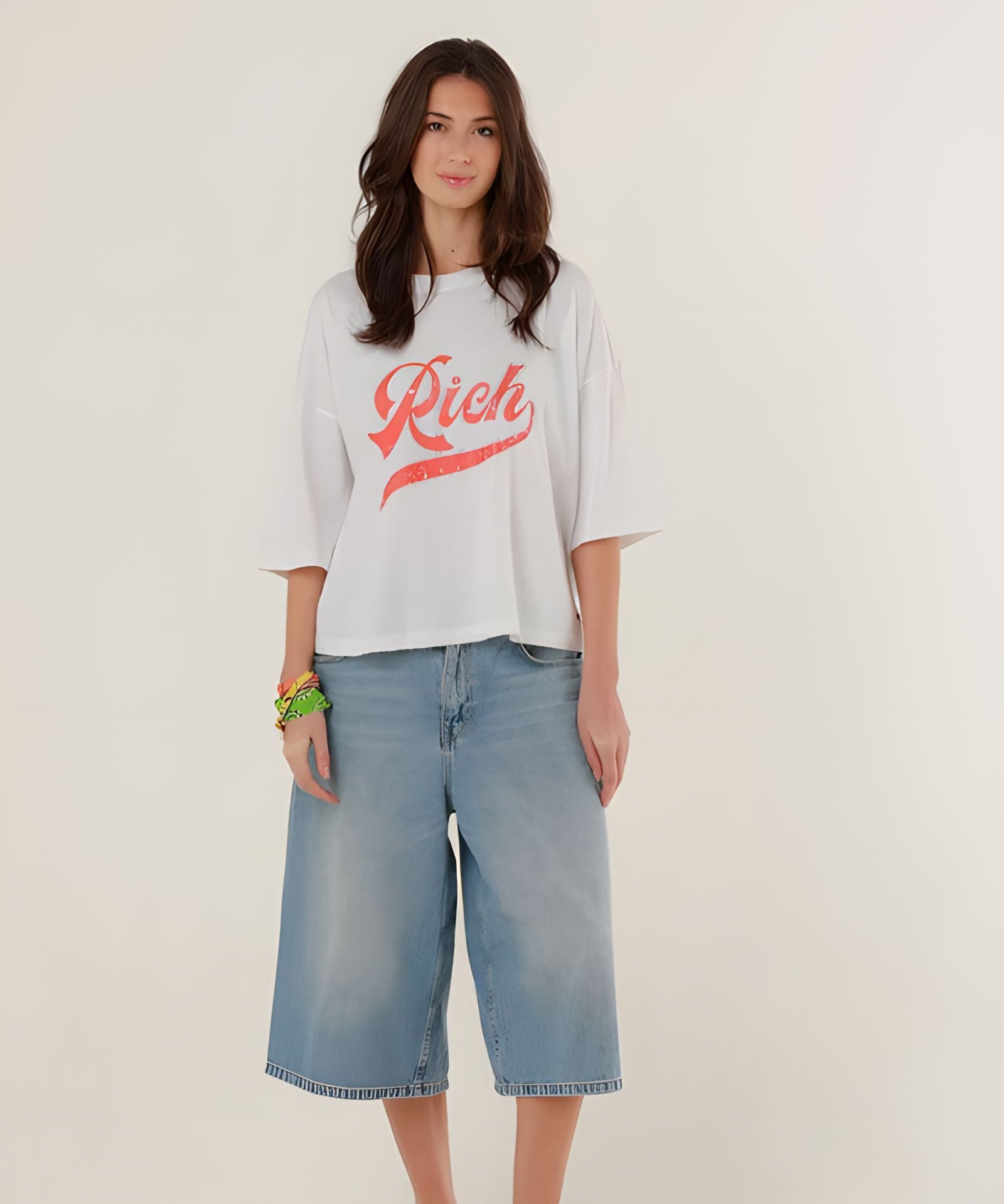 Full-length front view of a model styling the white cotton Tamara boyfriend t-shirt with wide-leg denim shorts.