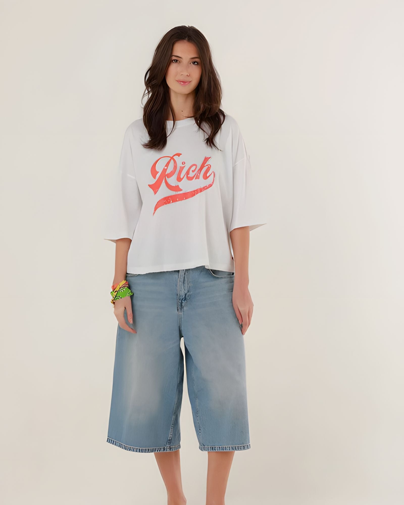 Full-length front view of a model styling the white cotton Tamara boyfriend t-shirt with wide-leg denim shorts.