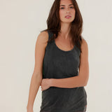 A mid-shot of a model wearing the charcoal carbone Top Mia tank top, highlighting the classic scoop neck and relaxed straight fit.