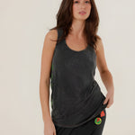 Front view of a model posing in the carbone Top Mia tank top paired with dark sweatpants, showcasing the lightweight and fluid cotton-modal fabric drape.