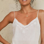 Close-up of the scalloped lace trim and eyelet detailing on a Mabe Apparel white cotton camisole.