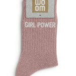 Rose gold glitter message socks with a white jacquard GIRL POWER inscription at the ankle, presented in their original Woom paper packaging.