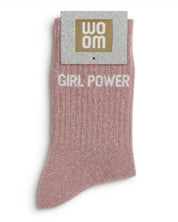 Rose gold glitter message socks with a white jacquard GIRL POWER inscription at the ankle, presented in their original Woom paper packaging.