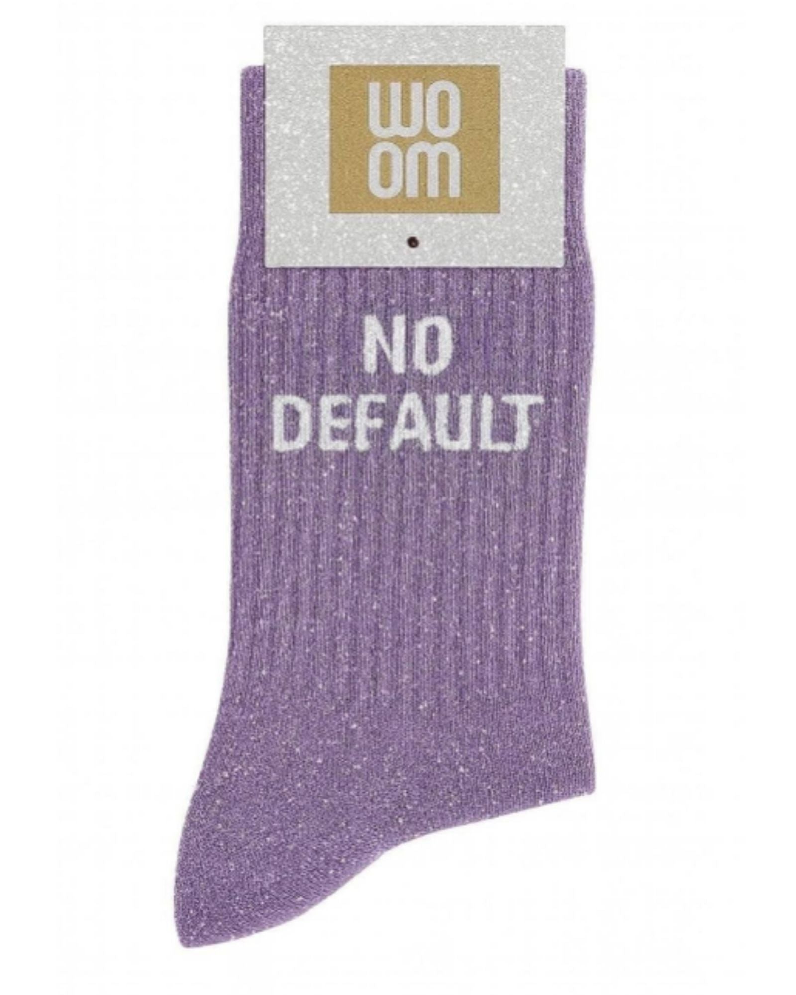Mauve glitter message socks with a white jacquard NO DEFAULT inscription at the ankle, presented in their original Woom paper packaging.