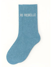 Side profile view of the turquoise glitter sock showing the comfortable elasticated ankle and the clean white REBELLE wording detail.