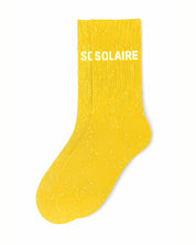 ide profile view of the yellow glitter sock showing the comfortable elasticated ankle and the clean white SOLAIRE wording detail.