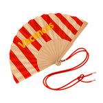 Close-up view of the opened red striped wooden fan, showcasing the fabric texture, contrast yellow lettering, and attached red contrast shoulder strap.