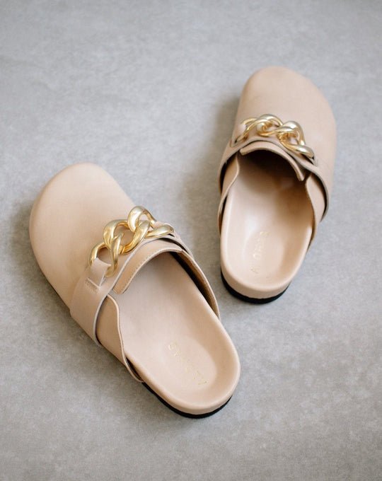 ALOHAS nude leather clogs shown as a pair, with gold chain-link trim across the front strap.