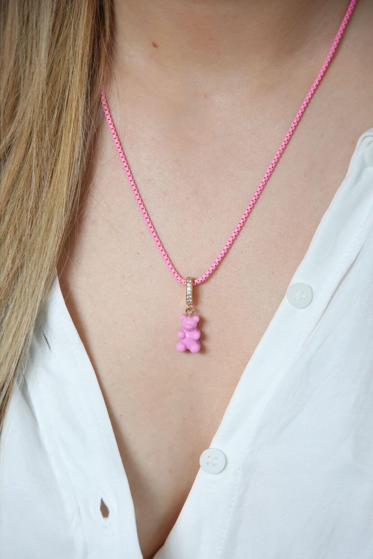 Crystal Haze candy pink Nostalgia Bear pendant worn on a pink cord necklace, resting at the collarbone.