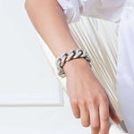 Woman wears white blouse and fashionable and effortlessly chic Flat Chain Bracelet in Glossy Grey by Vanessa Baroni, made in Italy.